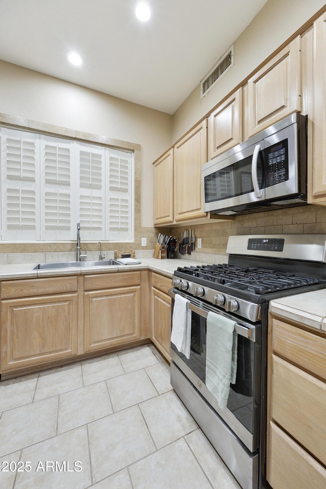 7262 W Firebird Dr, Glendale, AZ 85308 - kitchen with appliances with stainless steel finishes, a sink, light brown cabinetry, light countertops, and tasteful backsplash