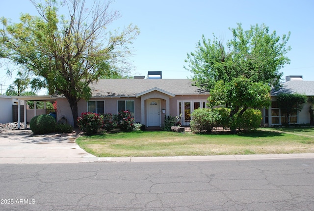 ranch-style home featuring concrete driveway, a front yard, stucco siding, and fence