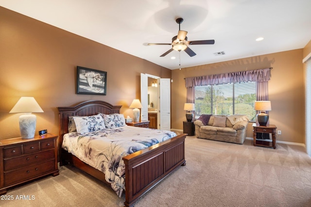 carpeted bedroom with ceiling fan and ensuite bath