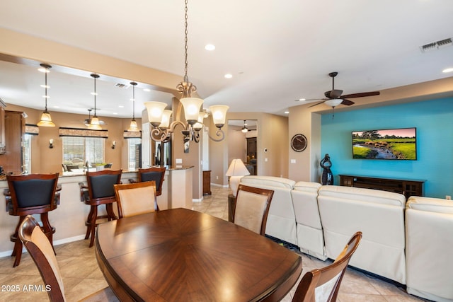 dining room with light tile patterned floors and ceiling fan with notable chandelier