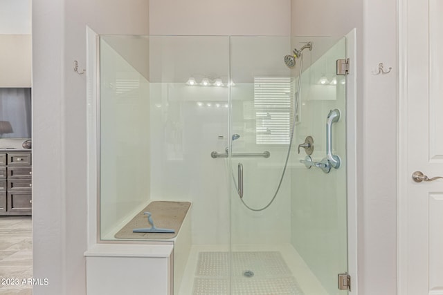 bathroom featuring a shower with door and tile floors