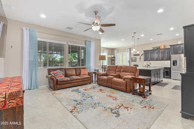 tiled living room with ceiling fan and sink