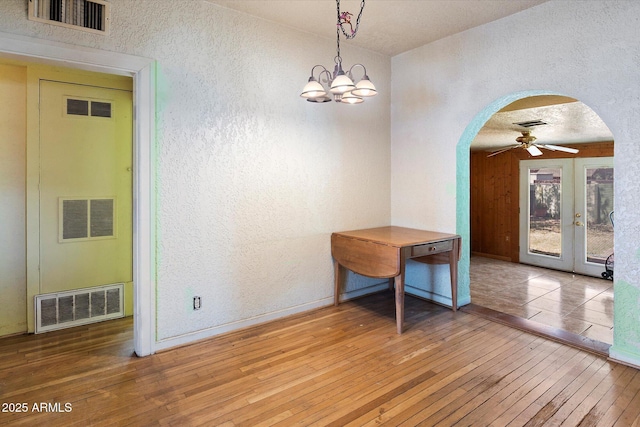 2230 N 12th St Rear, Rear, Phoenix, AZ 85006 - unfurnished dining area featuring a textured wall, arched walkways, hardwood / wood-style floors, a ceiling fan, and baseboards
