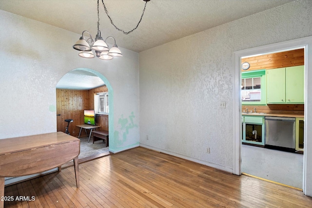 2230 N 12th St Rear, Rear, Phoenix, AZ 85006 - unfurnished dining area with a textured wall, light wood-style floors, arched walkways, a chandelier, and a sink