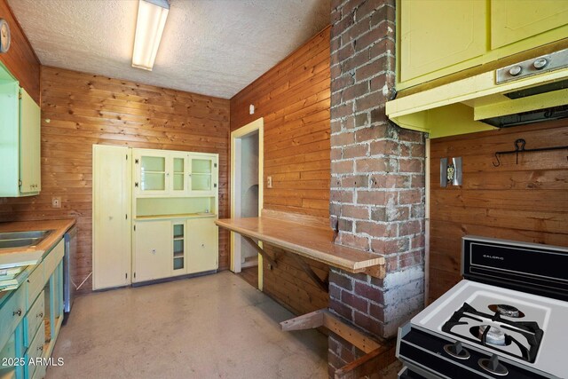 2230 N 12th St Rear, Rear, Phoenix, AZ 85006 - kitchen featuring wooden walls, gas range oven, a textured ceiling, green cabinetry, and concrete floors