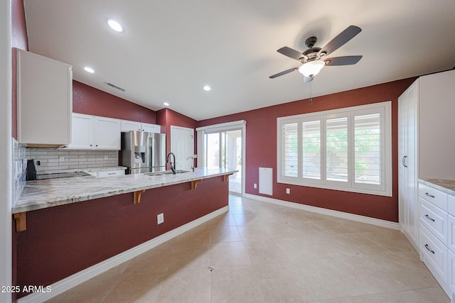 10371 W Pontiac Dr, Peoria, AZ 85382 - kitchen with stainless steel fridge with ice dispenser, stove, tasteful backsplash, a ceiling fan, and a kitchen breakfast bar