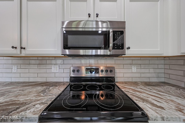 10371 W Pontiac Dr, Peoria, AZ 85382 - kitchen view of stainless steel appliances, white cabinetry, tasteful backsplash, and light stone counters
