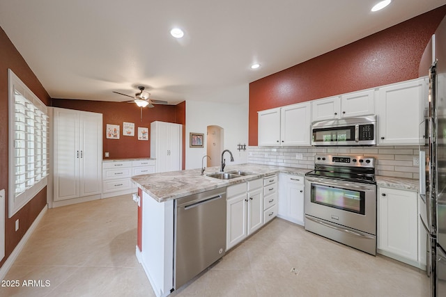 10371 W Pontiac Dr, Peoria, AZ 85382 - kitchen with stainless steel appliances, a sink, a peninsula, a ceiling fan, and backsplash