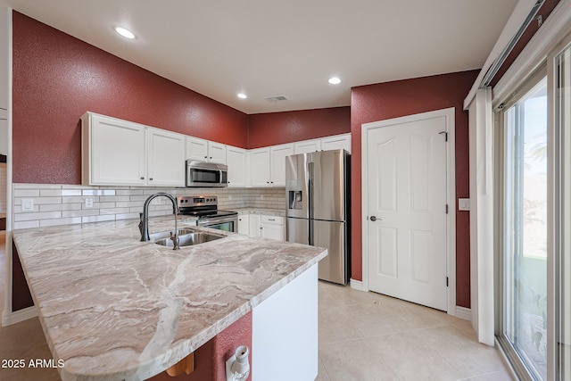 10371 W Pontiac Dr, Peoria, AZ 85382 - kitchen featuring stainless steel appliances, a peninsula, backsplash, white cabinets, and plenty of natural light