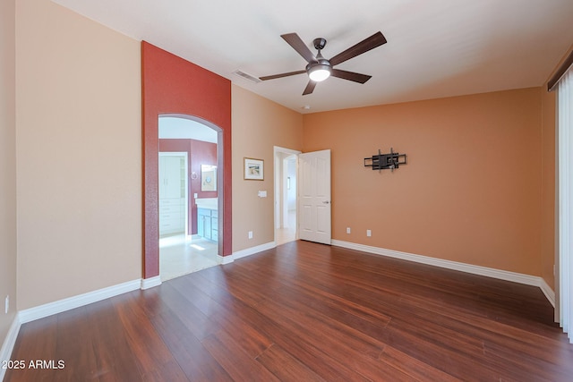 10371 W Pontiac Dr, Peoria, AZ 85382 - empty room featuring arched walkways, a ceiling fan, dark wood-style flooring, and baseboards