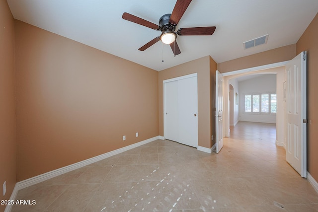 10371 W Pontiac Dr, Peoria, AZ 85382 - unfurnished bedroom featuring arched walkways, light tile patterned floors, baseboards, a closet, and a ceiling fan