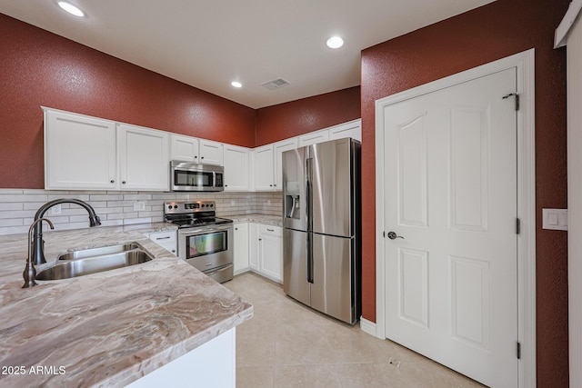 10371 W Pontiac Dr, Peoria, AZ 85382 - kitchen with appliances with stainless steel finishes, a sink, decorative backsplash, white cabinetry, and light stone counters