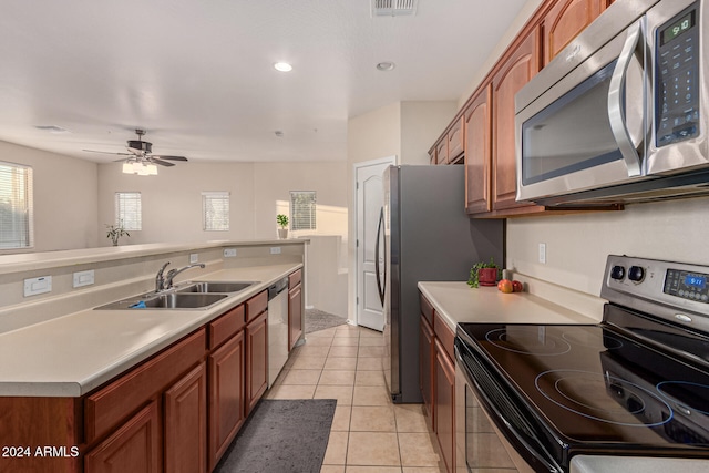 kitchen with sink, appliances with stainless steel finishes, ceiling fan, and light tile patterned floors