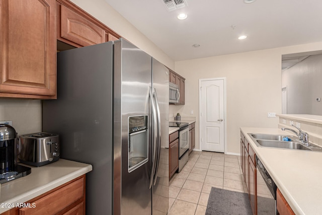 kitchen featuring light tile patterned floors, appliances with stainless steel finishes, and sink