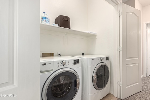 laundry area with independent washer and dryer and light colored carpet