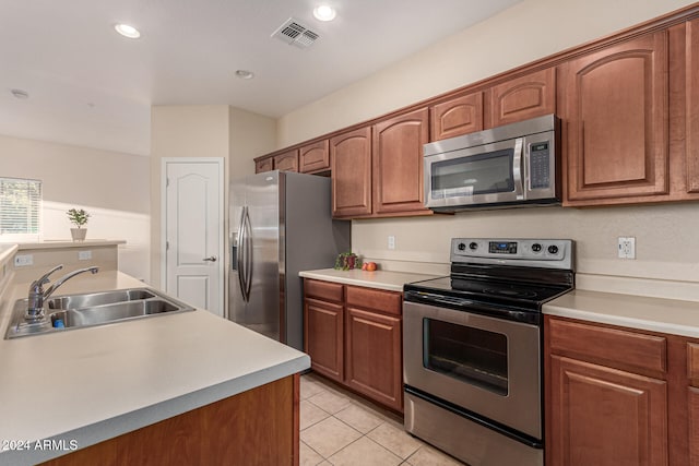 kitchen with appliances with stainless steel finishes, sink, and light tile patterned floors