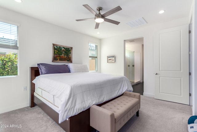 bedroom with ceiling fan, light colored carpet, and multiple windows