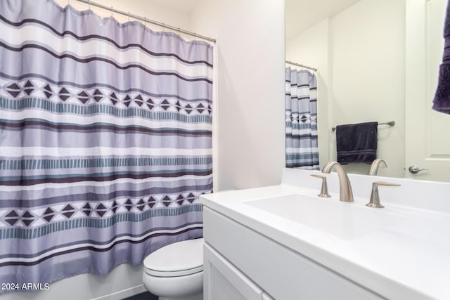 bathroom featuring curtained shower, vanity, and toilet