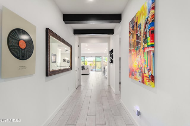 hall featuring light hardwood / wood-style flooring and beamed ceiling