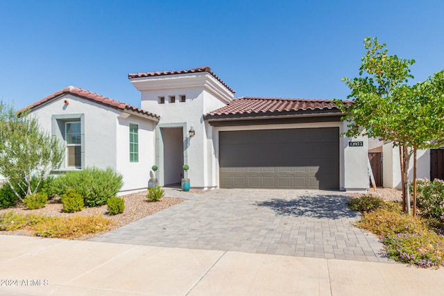 mediterranean / spanish home featuring a garage