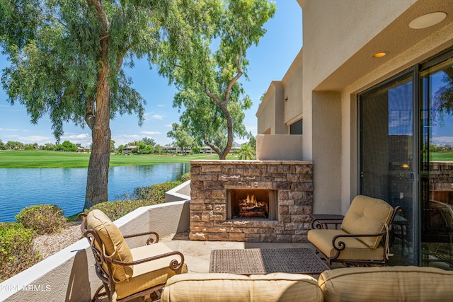 view of patio / terrace with an outdoor stone fireplace and a water view