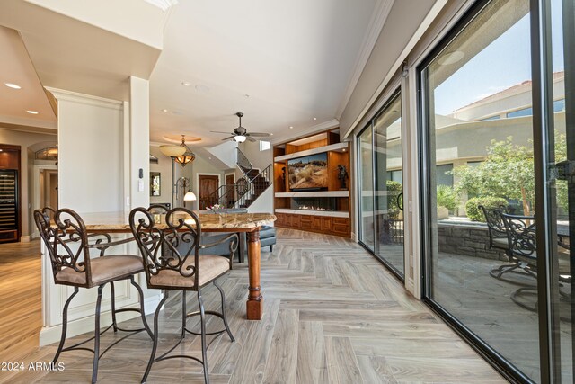 dining space featuring crown molding, light parquet flooring, a wealth of natural light, and ceiling fan