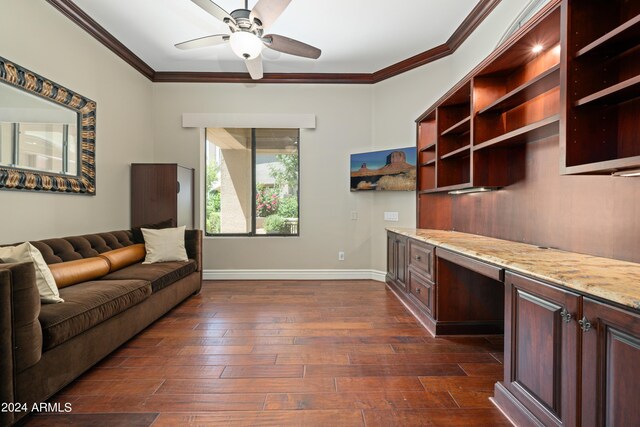 living room with crown molding, built in desk, ceiling fan, and dark hardwood / wood-style floors