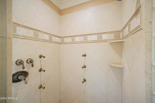 bathroom featuring ornamental molding and a tile shower