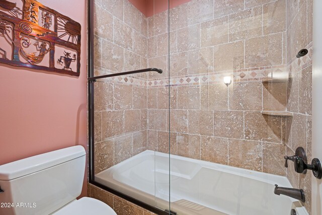 bathroom featuring toilet and enclosed tub / shower combo