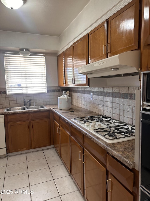 2115 W Myrtle Ave, Phoenix, AZ 85021 - kitchen with a sink, white gas stovetop, under cabinet range hood, light tile patterned floors, and decorative backsplash