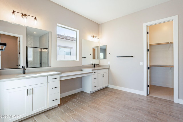 bathroom with a shower with door and vanity