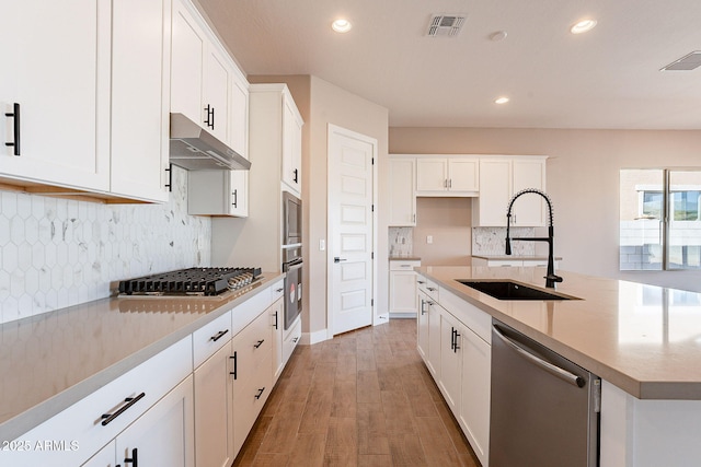 kitchen featuring white cabinetry, stainless steel appliances, light hardwood / wood-style floors, and sink