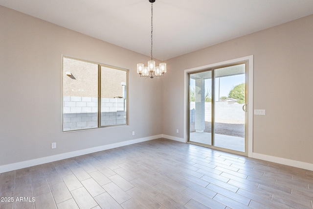 unfurnished room with an inviting chandelier