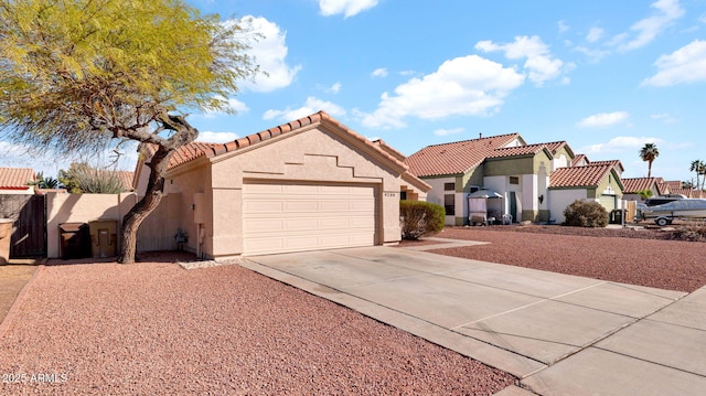 mediterranean / spanish home with a tile roof, stucco siding, a garage, a residential view, and driveway