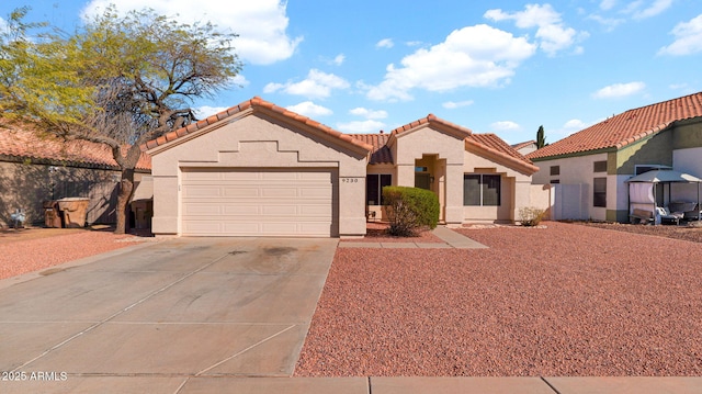 mediterranean / spanish home with driveway, a tile roof, a garage, and stucco siding