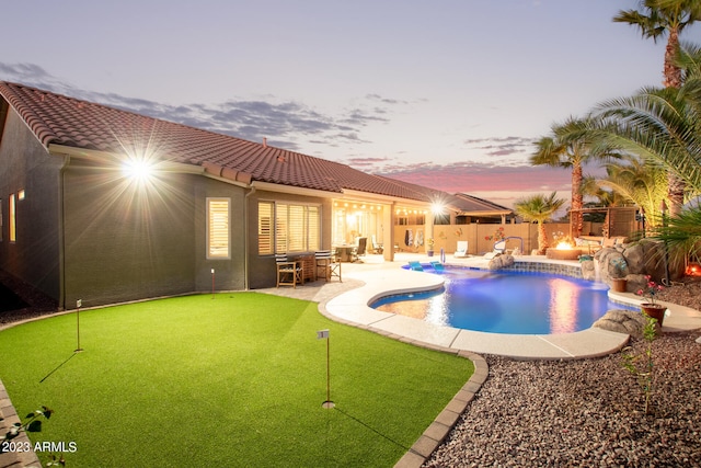 pool at dusk with a patio