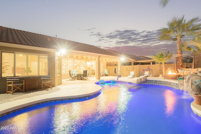 pool at dusk featuring a patio