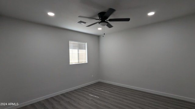 spare room with dark hardwood / wood-style floors and ceiling fan