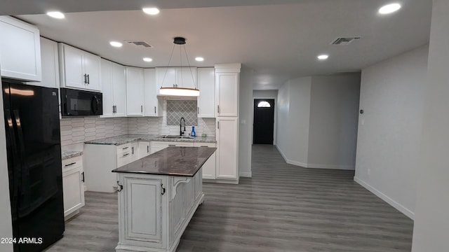 kitchen featuring pendant lighting, white cabinetry, a kitchen island, and black appliances