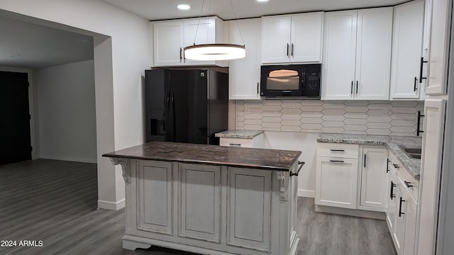 kitchen featuring white cabinets, decorative backsplash, a center island, and black appliances