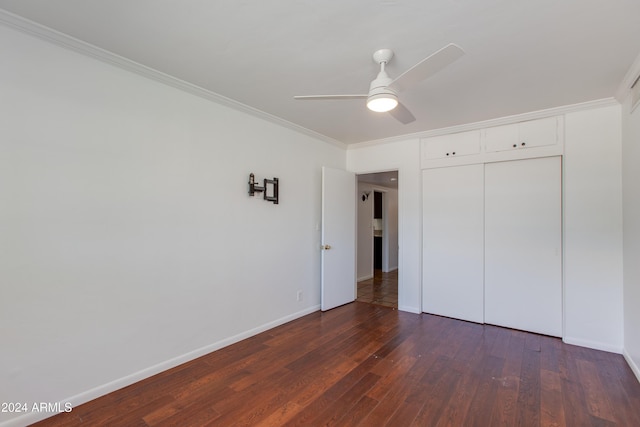 unfurnished bedroom with dark hardwood / wood-style flooring, ornamental molding, ceiling fan, and a closet