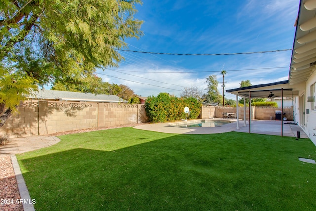 view of yard featuring a fenced in pool, a patio, and ceiling fan