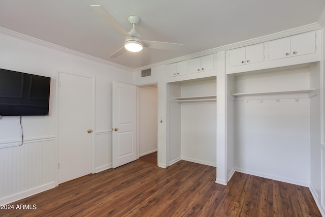 unfurnished bedroom featuring crown molding, dark hardwood / wood-style floors, ceiling fan, and two closets