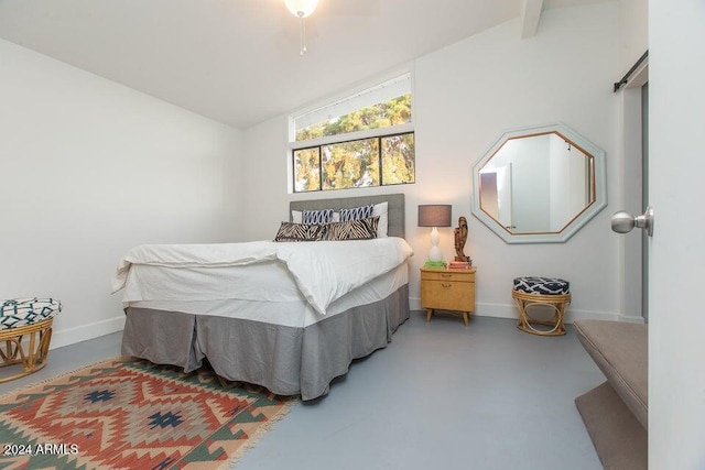 bedroom with concrete flooring and lofted ceiling with beams