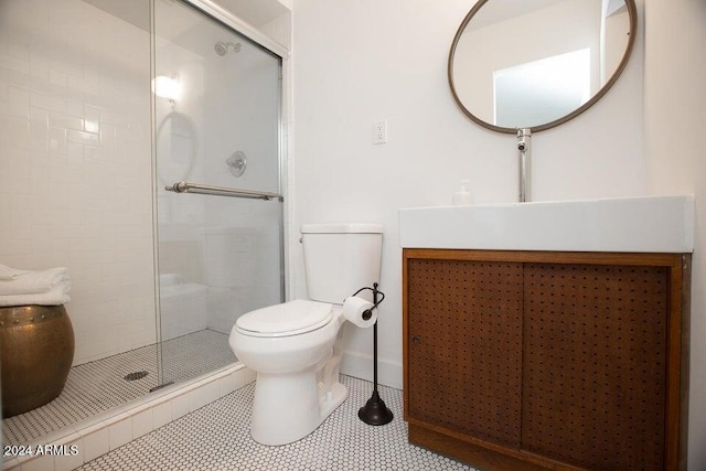 bathroom with vanity, a shower with shower door, tile patterned flooring, and toilet