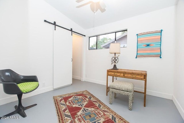 living area with a barn door, concrete flooring, and ceiling fan