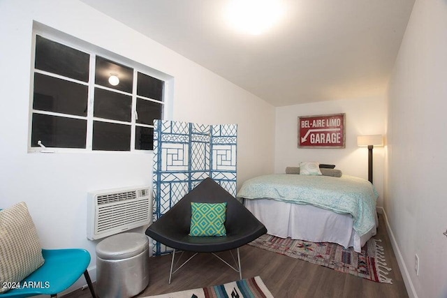 bedroom featuring wood-type flooring and an AC wall unit