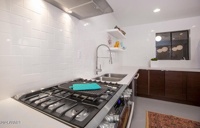 kitchen with dark brown cabinetry, sink, and stainless steel range