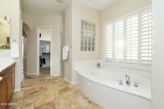 bathroom featuring plus walk in shower and vanity