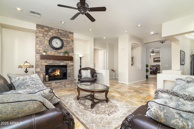 living room featuring ceiling fan and a fireplace